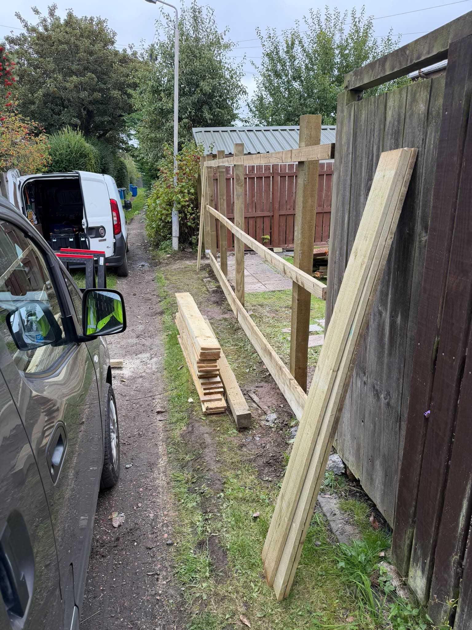 New pressure-treated fence posts and rails set in place along the Auldhouse boundary with cladding boards stacked ready