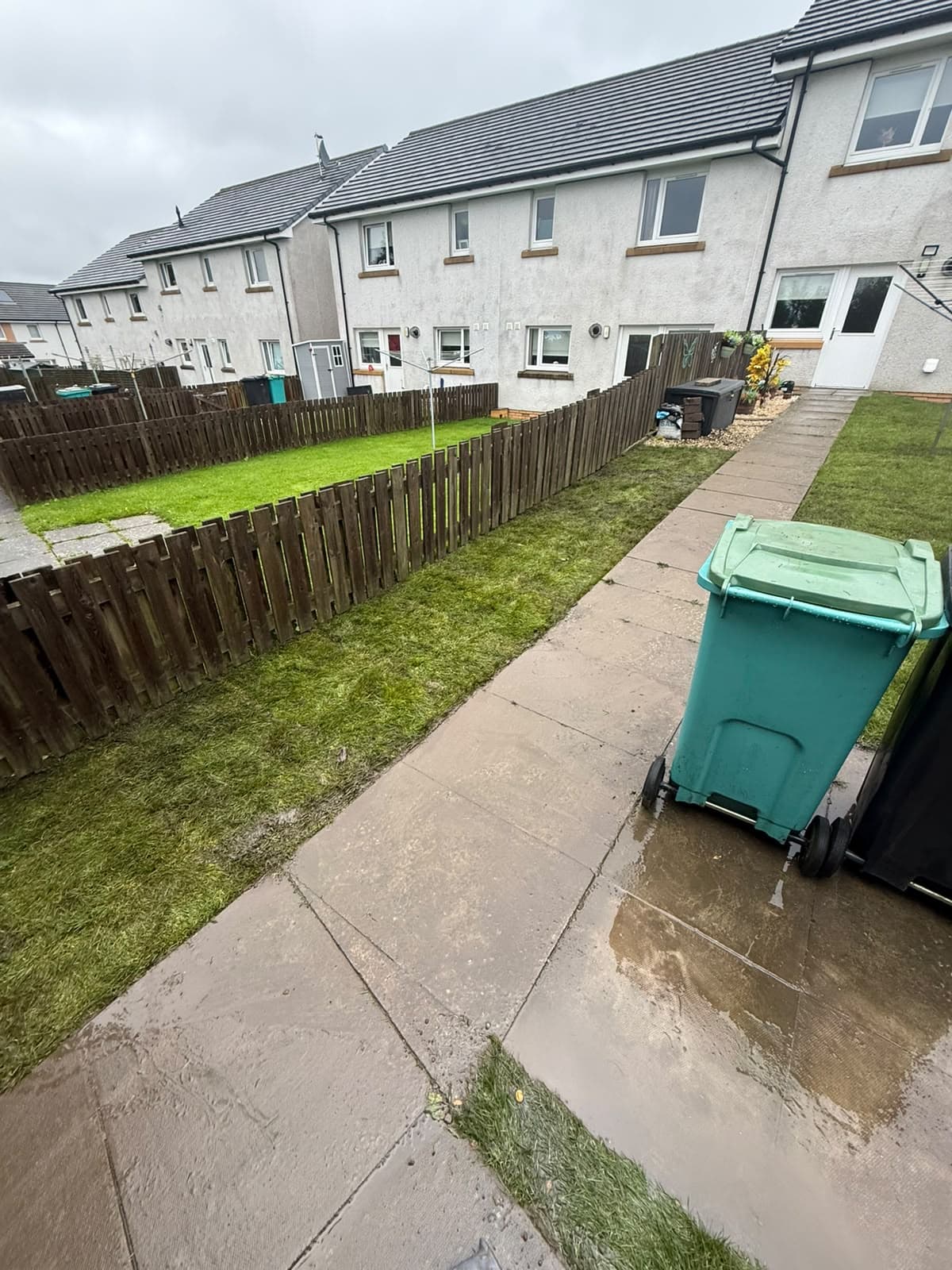 The same Chapelhall back garden finished with new turf running along the slab path and up to the boundary fence