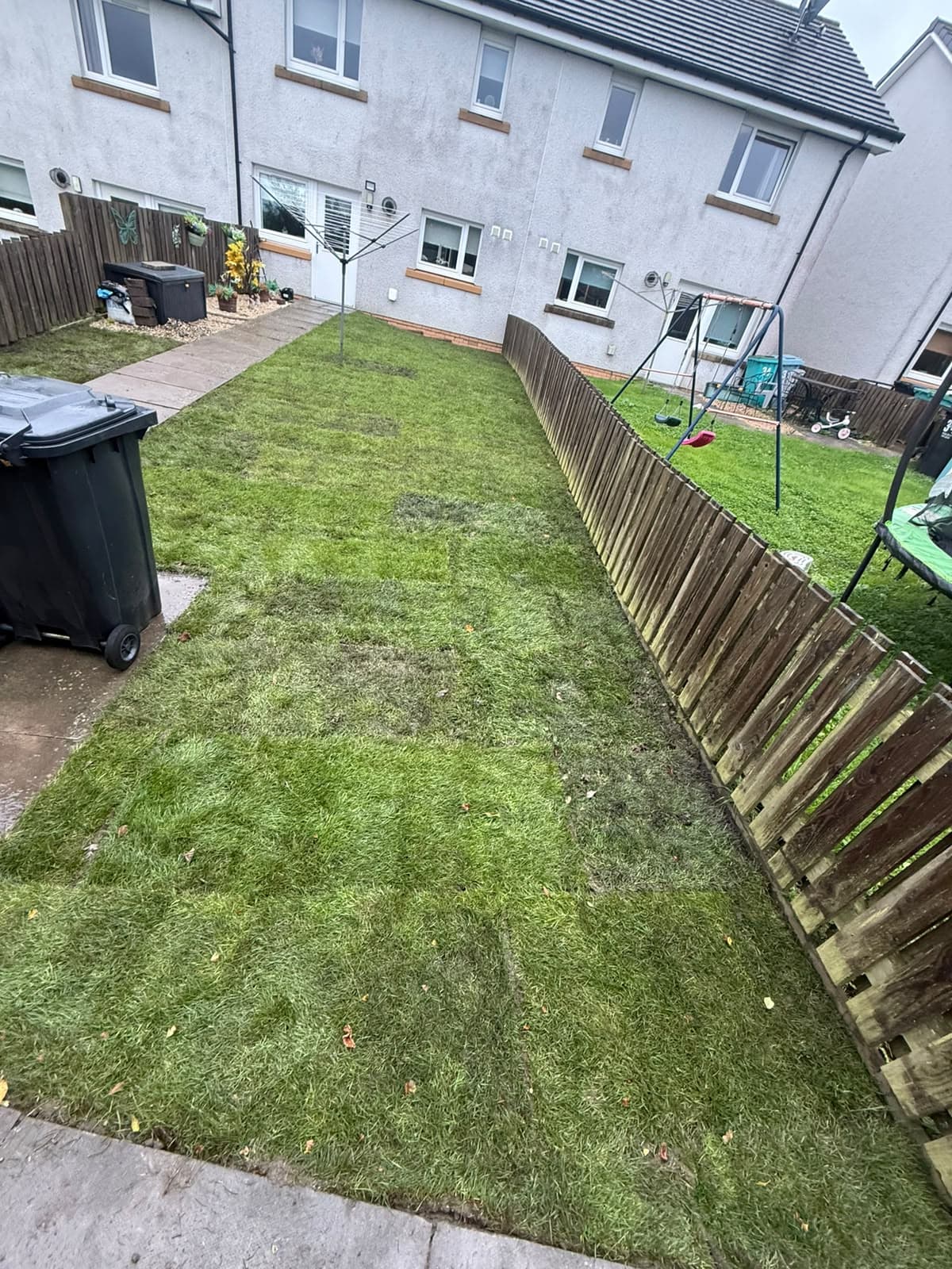 New turf laid the full length of a back garden in Chapelhall after the old waterlogged lawn was dug out