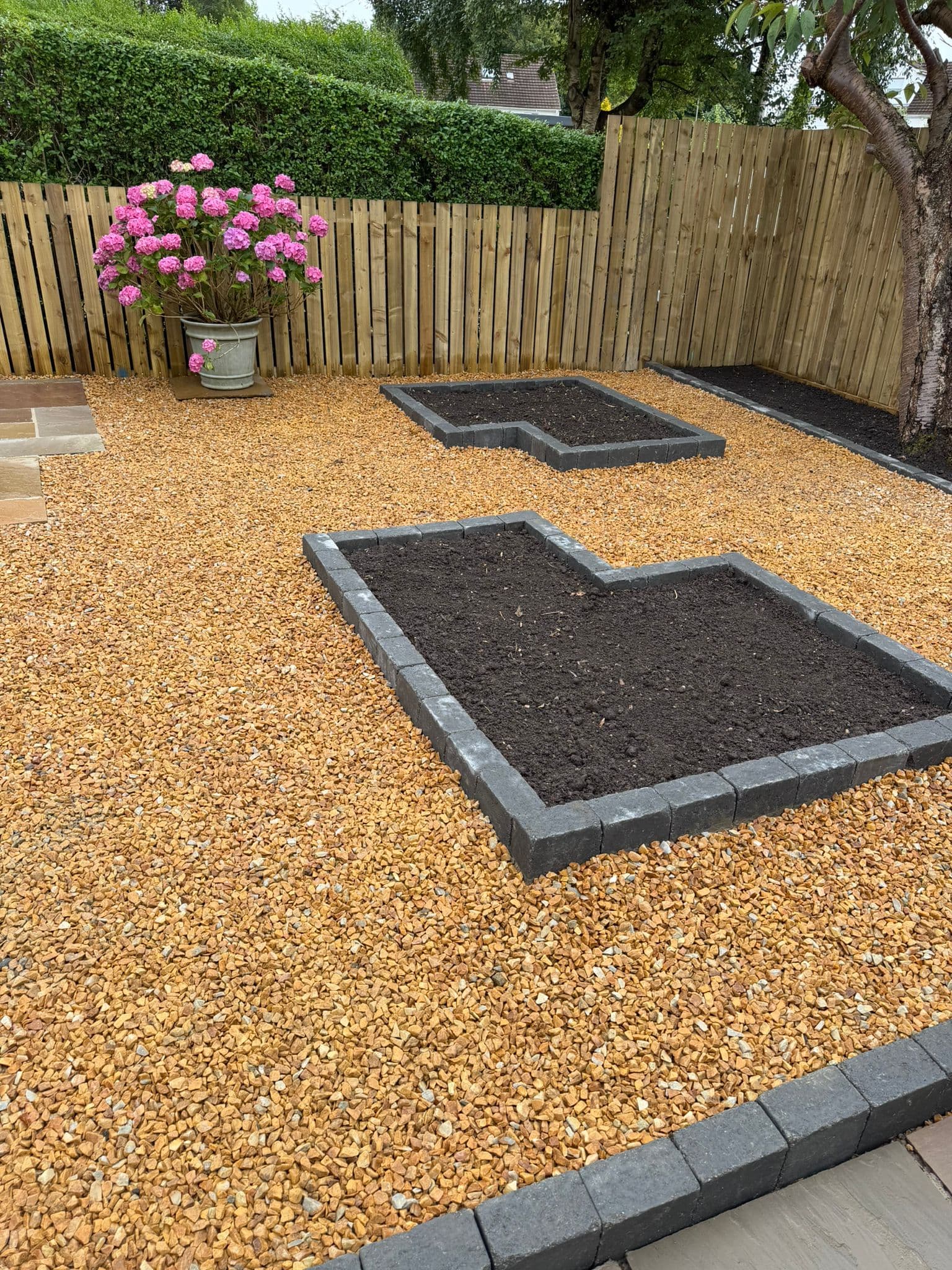 Finished rear garden with sandstone paving, gravel and new boundary fencing