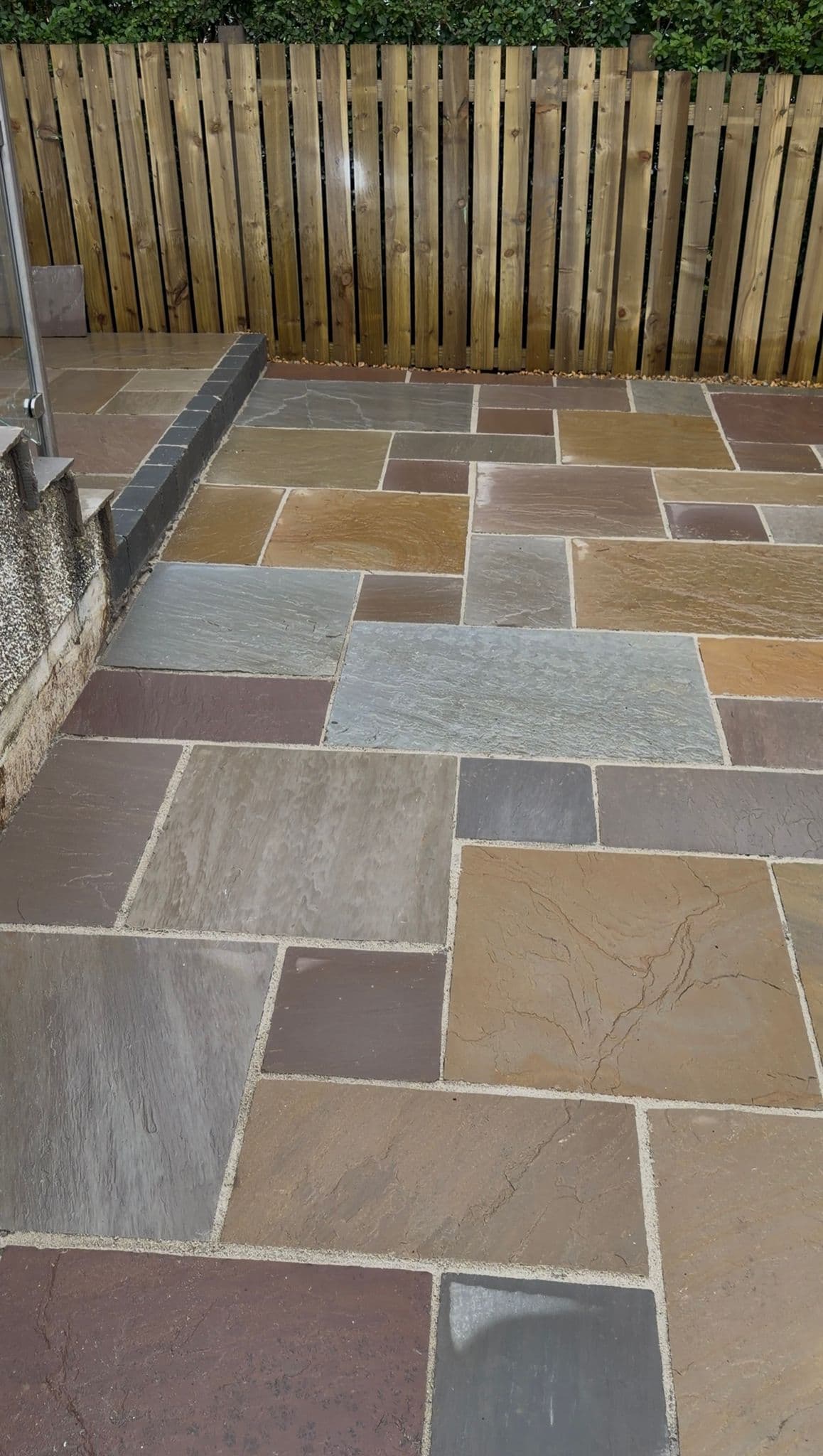 Sandstone patio and charcoal block edging in a completed rear garden