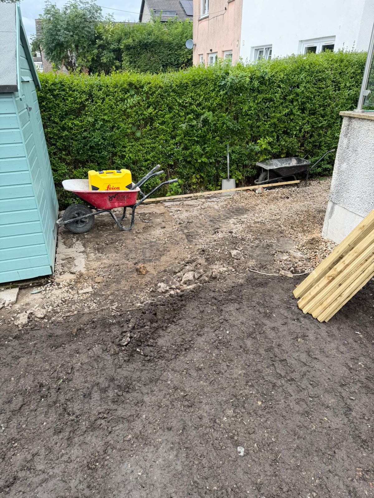 Sub-base being built up across a cleared rear garden ahead of paving