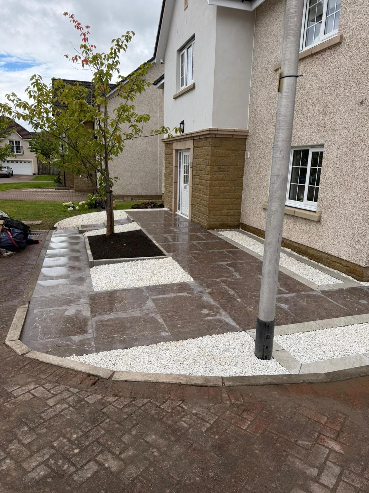 Finished porcelain path and white gravel border leading to a front door