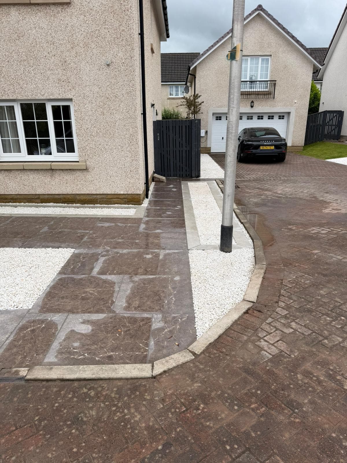 Finished driveway and porcelain path with white gravel borders